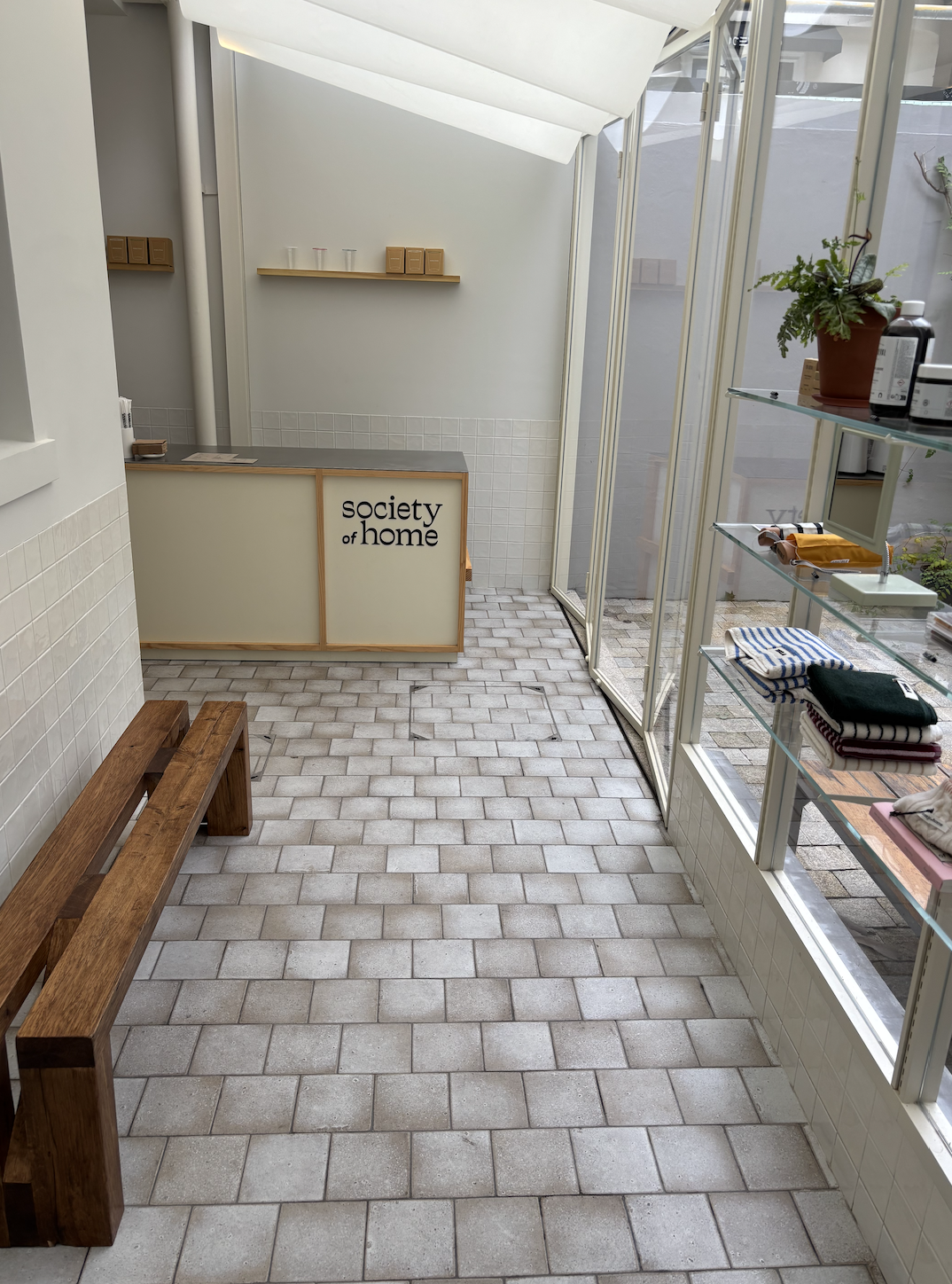 Espace café et salon communautaire baigné de lumière naturelle chez Society of Home, illustrant le slow retail et l'art de séjourner en boutique.