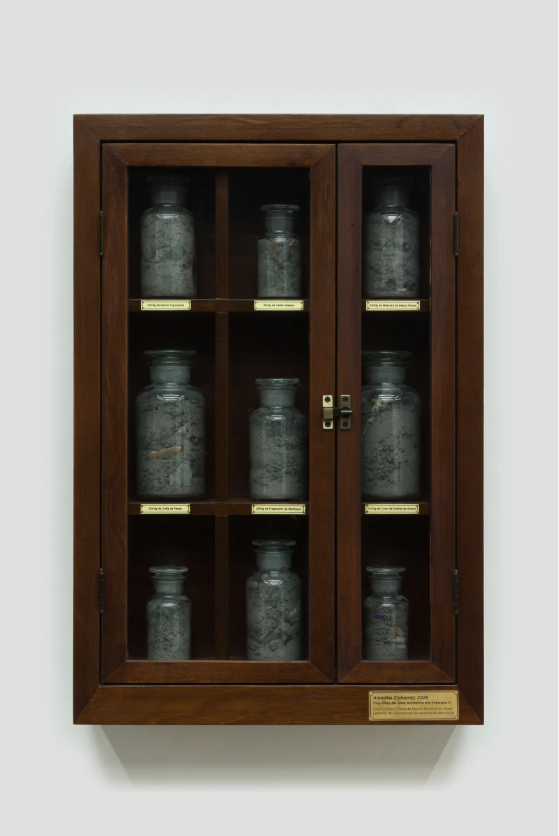 ALT : Cabinet en bois de Denilson Baniwa contenant des flacons remplis de cendres du Musée National du Brésil.